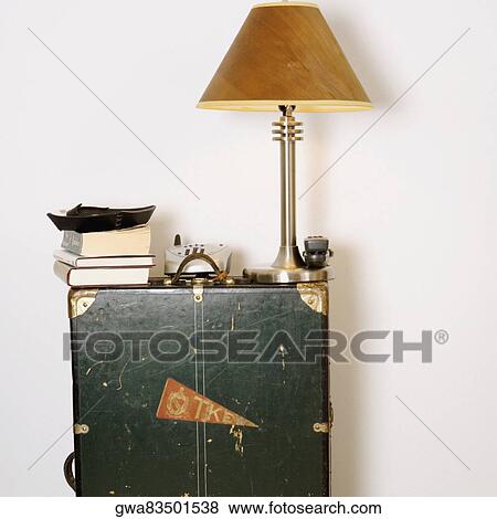 Lamp shade with a cordless phone and books on a cabinet View Large Photo Image Stock Photo - Lamp shade with a cordless phone and books on a cabinet. Fotosearch