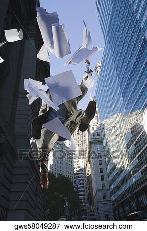 Low angle view of a businessman jumping and throwing papers View Large Photo Image Stock Photo - Low angle view of a businessman jumping and throwing papers. Fotosearch
