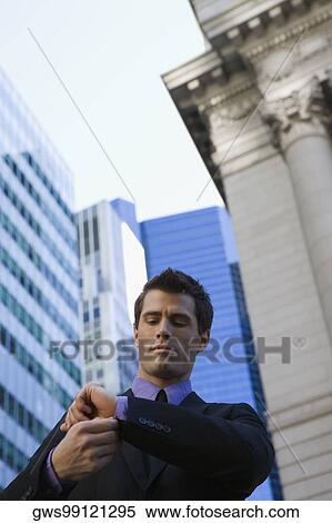 Low angle view of a businessman adjusting his cuff View Large Photo Image Stock Photography - Low angle view of a businessman adjusting his cuff. Fotosearch