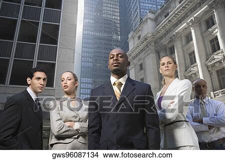 Picture - Low angle view of a businessman with his colleagues. Fotosearch