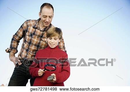 Low angle view of a mid adult man with his son View Large Photo Image Stock Photo - Low angle view of a mid adult man with his son. Fotosearch