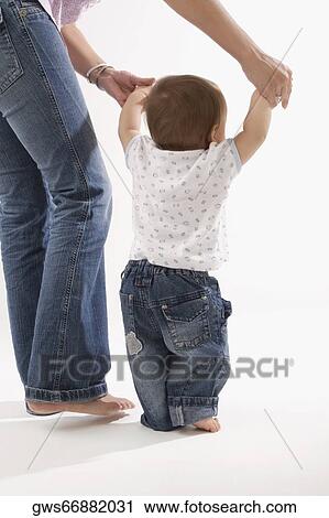 Stock Image - Low section view of a woman walking with her baby boy. Fotosearch