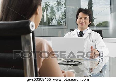Male doctor talking to a woman in a clinic View Large Photo Image Stock Photography - Male doctor talking to a woman in a clinic. Fotosearch