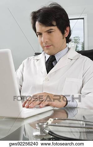 Male doctor using a laptop in a clinic View Large Photo Image Stock Image - Male doctor using a laptop in a clinic. Fotosearch