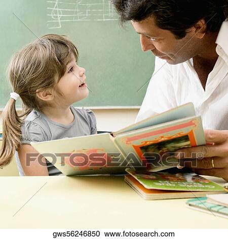 Male teacher teaching his student in a classroom View Large Photo Image Stock Image - Male teacher teaching his student in a classroom. Fotosearch