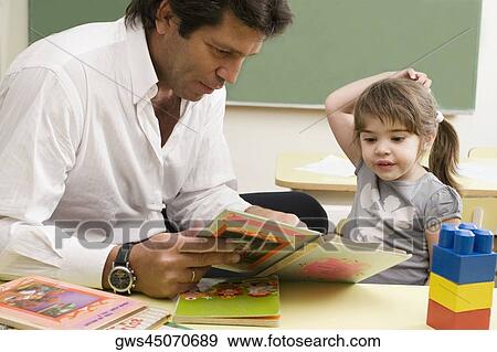 Male teacher teaching his student in a classroom View Large Photo Image Stock Photo - Male teacher teaching his student in a classroom. Fotosearch