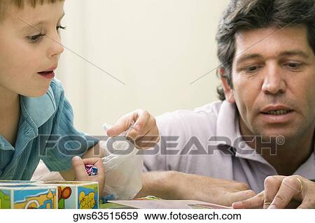 Stock Photo - Male teacher teaching his student in a classroom. Fotosearch