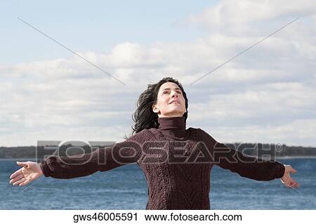 Mature woman standing on the beach with her arms outstretched View Large Photo Image Stock Image - Mature woman standing on the beach with her arms outstretched. Fotosearch