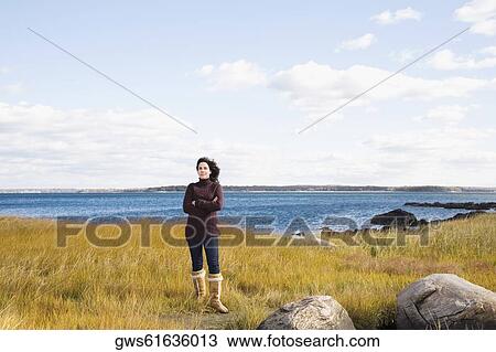 Mature woman standing on the beach with her arms crossed View Large Photo Image Stock Image - Mature woman standing on the beach with her arms crossed. Fotosearch