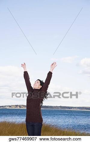 Mature woman standing on the beach with her arms raised View Large Photo Image Stock Photo - Mature woman standing on the beach with her arms raised. Fotosearch