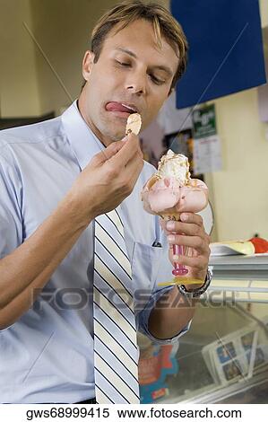 Mid adult man eating an ice cream View Large Photo Image Stock Photography - Mid adult man eating an ice cream. Fotosearch