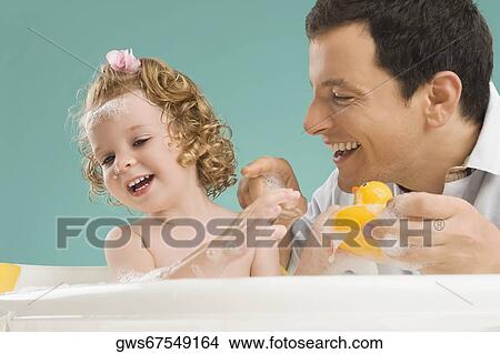 Mid adult man playing with his daughter View Large Photo Image Picture - Mid adult man playing with his daughter. Fotosearch