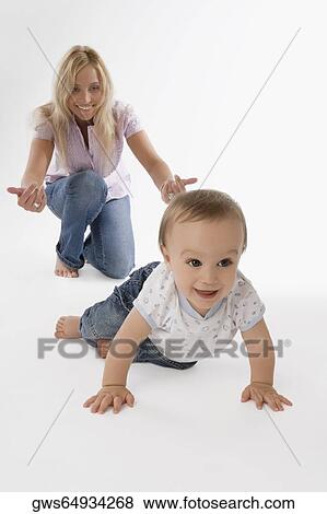 Mid adult woman playing with her baby boy and smiling View Large Photo Image Stock Photo - Mid adult woman playing with her baby boy and smiling. Fotosearch