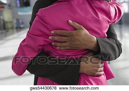 Mid section view of a businesswoman and a businessman embracing each other at an airport View Large Photo Image Stock Photo - Mid section view of a businesswoman and a businessman embracing each other at an airport. Fotosearch
