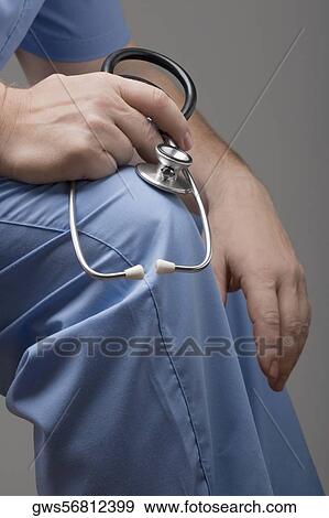 Stock Photo - Mid section view of a person holding a stethoscope. Fotosearch