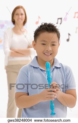 Portrait of a boy holding a recorder flute and smiling View Large Photo Image Picture - Portrait of a boy holding a recorder flute and smiling. Fotosearch