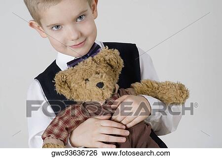 Stock Photograph - Portrait of a boy holding a teddy bear. Fotosearch