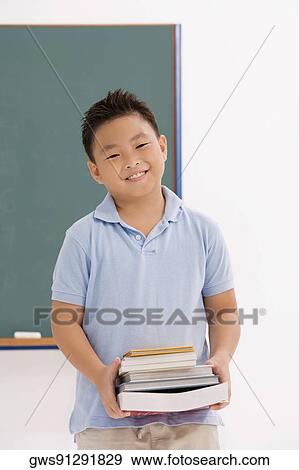Portrait of a boy holding books and smiling View Large Photo Image Stock Photo - Portrait of a boy holding books and smiling. Fotosearch