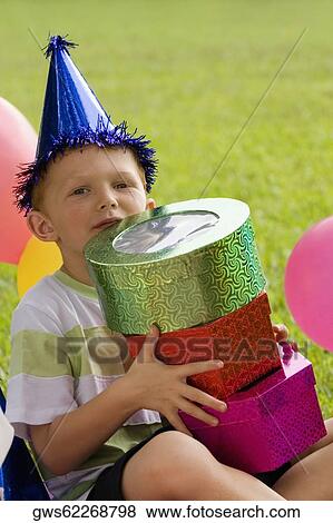 Stock Photo - Portrait of a boy holding gifts. Fotosearch