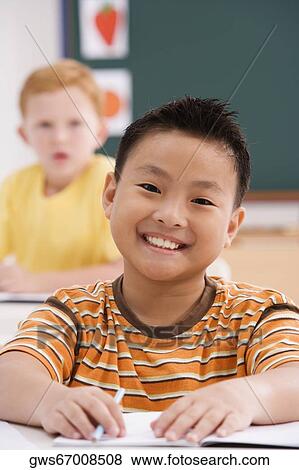 Portrait of a boy smiling in a classroom View Large Photo Image Stock Photo - Portrait of a boy smiling in a classroom. Fotosearch