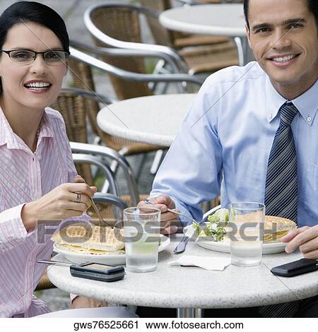 Portrait of a businessman and a businesswoman having lunch at a sidewalk cafe View Large Photo Image Stock Image - Portrait of a businessman and a businesswoman having lunch at a sidewalk cafe. Fotosearch