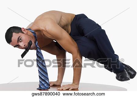Portrait of a businessman doing a handstand on a table with a mobile phone in his mouth View Large Photo Image Stock Image - Portrait of a businessman doing a handstand on a table with a mobile phone in his mouth. Fotosearch
