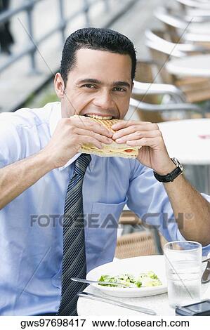Portrait of a businessman eating a cheese sandwich View Large Photo Image Stock Photo - Portrait of a businessman eating a cheese sandwich. Fotosearch
