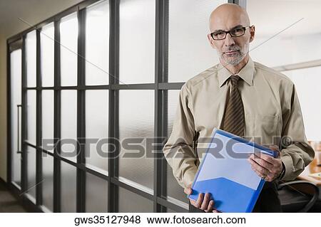 Stock Photo - Portrait of a businessman holding a file. Fotosearch