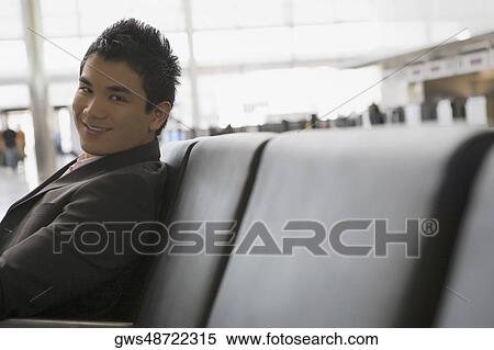 Portrait of a businessman sitting at an airport and smiling View Large Photo Image Stock Photography - Portrait of a businessman sitting at an airport and smiling. Fotosearch