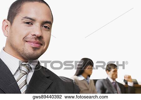 Portrait of a businessman smiling with other business executives in a board room View Large Photo Image Stock Image - Portrait of a businessman smiling with other business executives in a board room. Fotosearch