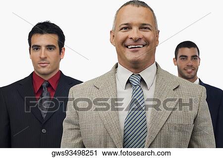 Portrait of a businessman smiling with two businessmen standing behind him View Large Photo Image Stock Image - Portrait of a businessman smiling with two businessmen standing behind him. Fotosearch