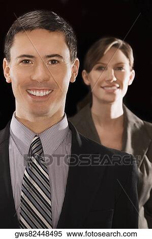 Portrait of a businessman smiling with a businesswoman standing behind him View Large Photo Image Stock Photography - Portrait of a businessman smiling with a businesswoman standing behind him. Fotosearch