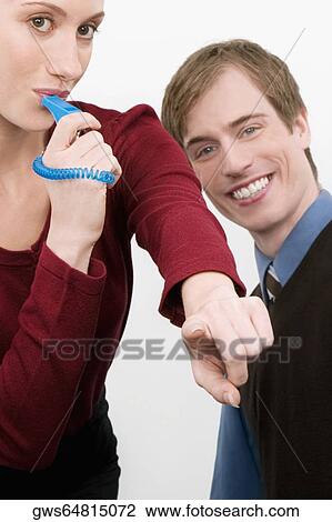Portrait of a businesswoman blowing a whistle with a businessman standing beside her View Large Photo Image Stock Image - Portrait of a businesswoman blowing a whistle with a businessman standing beside her. Fotosearch