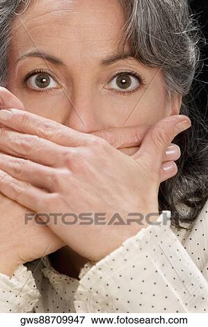 Portrait of a businesswoman covering mouth with hands View Large Photo Image Stock Photo - Portrait of a businesswoman covering mouth with hands. Fotosearch