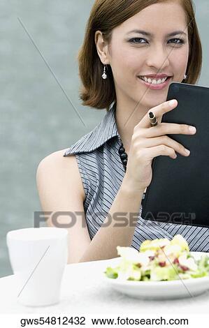 Portrait of a businesswoman holding a ring binder at a sidewalk cafe View Large Photo Image Stock Image - Portrait of a businesswoman holding a ring binder at a sidewalk cafe. Fotosearch