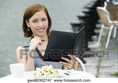 Portrait of a businesswoman holding a ring binder at a sidewalk cafe View Large Photo Image Stock Photo - Portrait of a businesswoman holding a ring binder at a sidewalk cafe. Fotosearch
