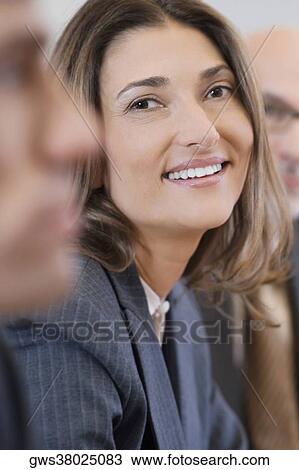 Stock Image - Portrait of a businesswoman smiling in a board room. Fotosearch