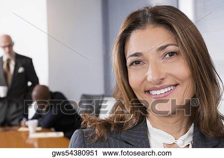 Portrait of a businesswoman smiling with other business executives in a board room View Large Photo Image Stock Image - Portrait of a businesswoman smiling with other business executives in a board room. Fotosearch