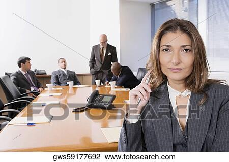 Portrait of a businesswoman smiling with other business executives in a board room View Large Photo Image Stock Image - Portrait of a businesswoman smiling with other business executives in a board room. Fotosearch