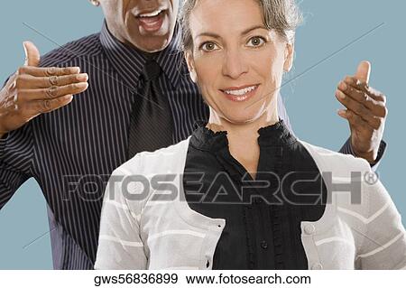 Portrait of a businesswoman smiling with a businessman shouting at her View Large Photo Image Stock Photo - Portrait of a businesswoman smiling with a businessman shouting at her. Fotosearch