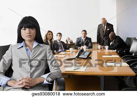 Portrait of a businesswoman smiling with other business executives in a board room View Large Photo Image Stock Photo - Portrait of a businesswoman smiling with other business executives in a board room. Fotosearch