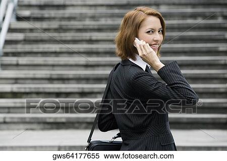 Portrait of a businesswoman talking on a mobile phone and smiling View Large Photo Image Stock Photography - Portrait of a businesswoman talking on a mobile phone and smiling. Fotosearch
