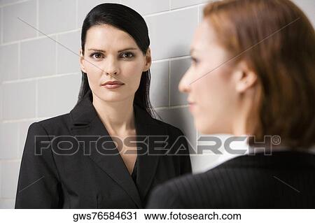 Portrait of a businesswoman with another businesswoman standing in front of her View Large Photo Image Stock Image - Portrait of a businesswoman with another businesswoman standing in front of her. Fotosearch
