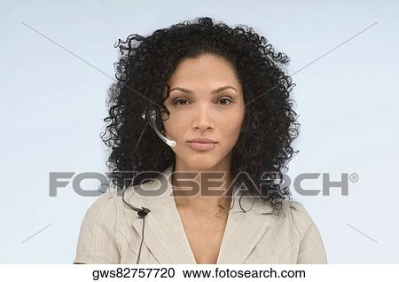 Stock Image - Portrait of a female customer service representative wearing a headset. Fotosearch
