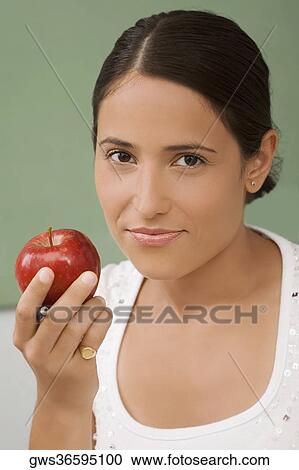 Portrait of a female teacher holding an apple and smiling View Large Photo Image Stock Image - Portrait of a female teacher holding an apple and smiling. Fotosearch