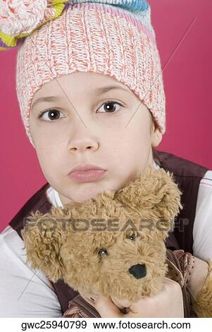 Stock Photo - Portrait of a girl holding a teddy bear. Fotosearch