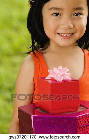 Portrait of a girl holding gifts and smiling View Large Photo Image Stock Image - Portrait of a girl holding gifts and smiling. Fotosearch