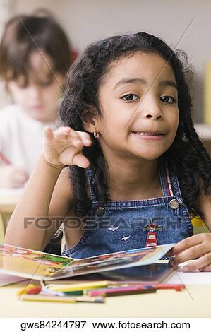 Stock Photo - Portrait of a girl making a face with a boy sitting behind her. Fotosearch