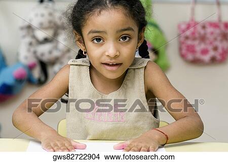 Picture - Portrait of a girl making handprints on a sheet of paper. Fotosearch