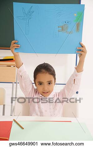 Stock Image - Portrait of a girl showing a drawing. Fotosearch